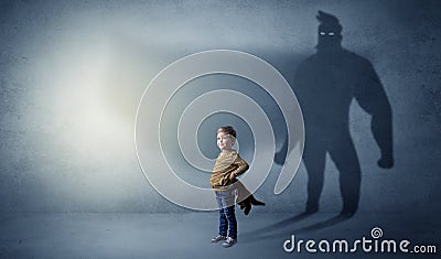 Cute kid with hero shadow behind Stock Photo