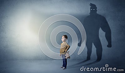 Cute kid with hero shadow behind Stock Photo