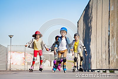 Cute kids on roller skates riding outdoors Stock Photo