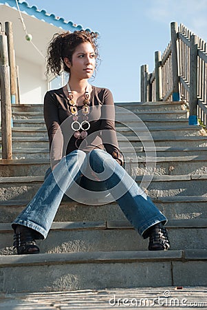 Cute lady in casual clothes sitting on stairs Stock Photo