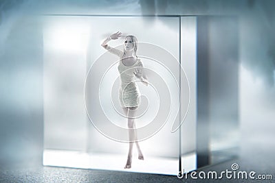 Cute lady imprisoned in a glass cube Stock Photo