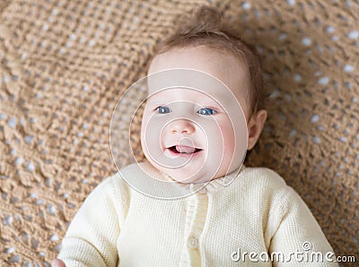 Cute laughing little baby on brown knitted blanket Stock Photo