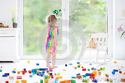 Cute laughing toddler girl playing with colorful blocks Stock Photo