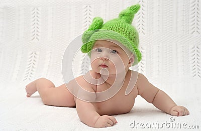 Cute little baby in funny green hat Stock Photo