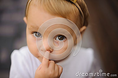 Cute little baby girl picking her nose Stock Photo