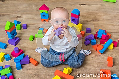 Cute little baby girl playing with colorful toy blocks Stock Photo