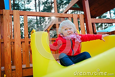 Cute little baby girl slide on playground outdoors Stock Photo