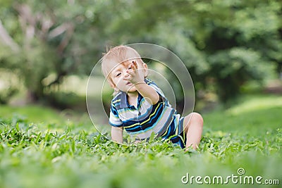 Cute little baby in summer park on the grass. Sweet baby outdoor Editorial Stock Photo