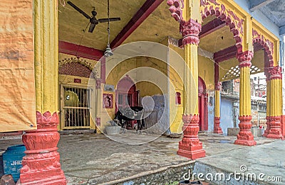 a cute little black calf tide near Brightly Painted Krishna Temple Editorial Stock Photo