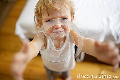 Cute little blond child is crying. Crying child, stress, pain, sadness, despair Stock Photo