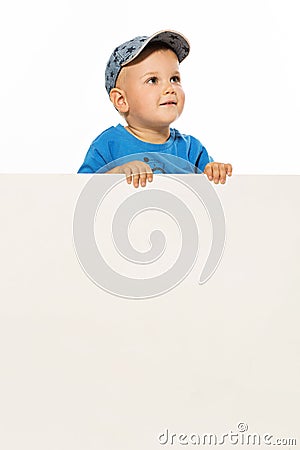 Cute little boy is above white blank poster looking up Stock Photo