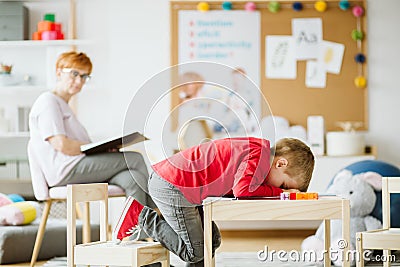 Cute little boy with ADHD during session with professional therapist Stock Photo