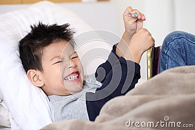 Cute little boy with digital tablet, early learning.asian boy playing game on the bedroom. Stock Photo