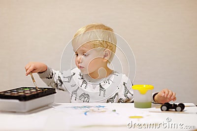 Cute little boy drawing with colorful paints at home Stock Photo