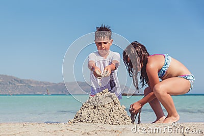 Cute little boy and a girl building a sand castle on a tropical sea shore Stock Photo