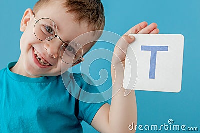 Cute little boy with letter on blue background. Child learning a letters. Alphabet Stock Photo