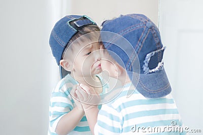 Cute little boy looking at mirror , kid self talk via mirror Stock Photo