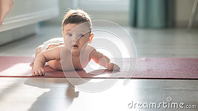 Cute little boy lying on his forearms on the floor. Stock Photo