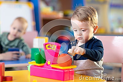 Cute little boy playing with abacus in nursery. Preschooler having fun with educational toy in daycare or creche. Smart Stock Photo