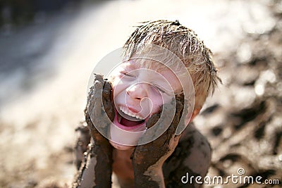 Cute Little Boy Playing Outside in the Mud with a Dirty Face Stock Photo