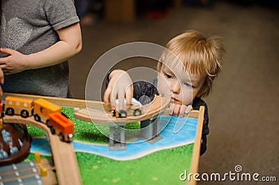 Cute little boy is playing with toy wooden train Stock Photo