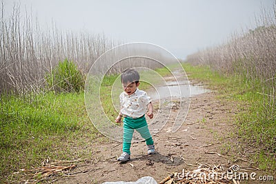 cute little boy playing in the wild grass Stock Photo