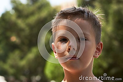 Cute little boy portrait in the park with green trees on backgro Stock Photo