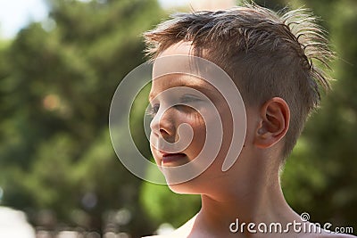 Cute little boy portrait in the park with green trees on backgro Stock Photo