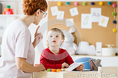 Cute little boy with problems during meeting with therapist Stock Photo