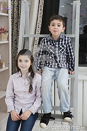 Cute little boy and sister sitting on the staircase Stock Photo