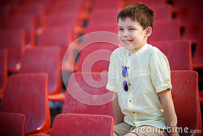 Cute little boy sits on a tribune Stock Photo