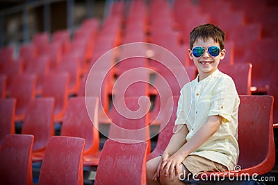 Cute little boy sits on a tribune Stock Photo