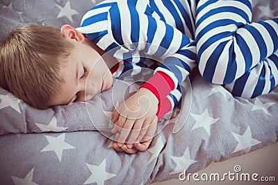Cute little boy sleeps in pajames on bed. Fokus above Stock Photo