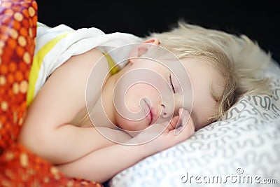 Cute little boy sweet sleeping. Afternoon sleep of preschooler child. Tired baby having nap. Cozy bedding sheets for kids Stock Photo