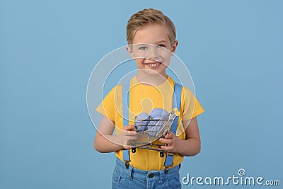 Child and Easter. Smiling blond boy, 6 years old, is holding a colors eggs. Stock Photo