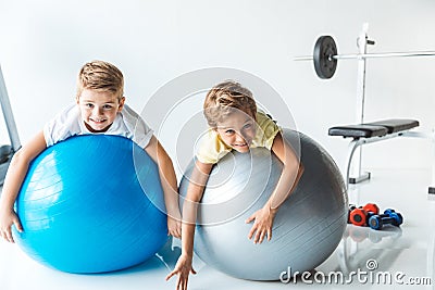 cute little boys exercising on fitness balls and smiling at camera Stock Photo
