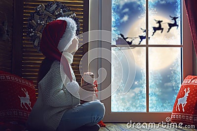 Girl by window at Christmas Stock Photo