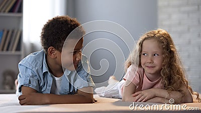 Cute little children clumsily flirting with each other, first childhood love Stock Photo