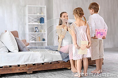 Cute little children hiding greeting cards for their mother behind back at home Stock Photo
