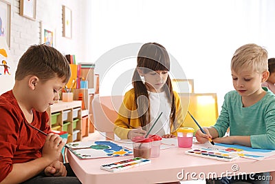 Cute children painting at table in room Stock Photo