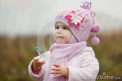 A cute little girl blows bubbles in autumn Stock Photo