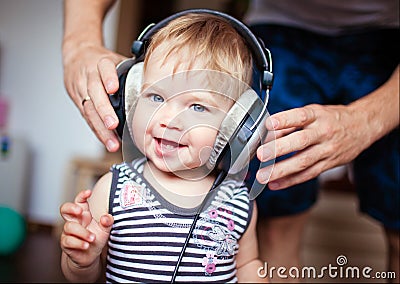 Cute little girl with blue eyes in the headphones, smiling Stock Photo