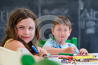 Cute little girl and boy drawing and painting with colorful markers pens at kindergarten. Creative activities kids club Stock Photo