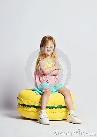 Cute little girl in bright clothes have fun at the birthday party fun room decoration candy macarons Stock Photo