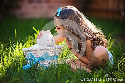 Cute little girl with a bunny rabbit has a easter at green grass Stock Photo