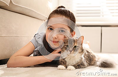 Cute little girl with cat lying on carpet. First pet Stock Photo