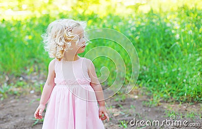 Cute little girl child with curly hair wearing a pink dress Stock Photo