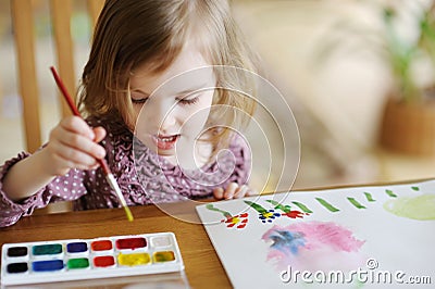 Cute little girl is drawing with paints Stock Photo