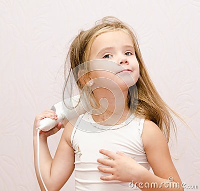 Cute little girl dries hair Stock Photo