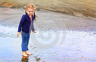 Cute little girl explores beach Stock Photo